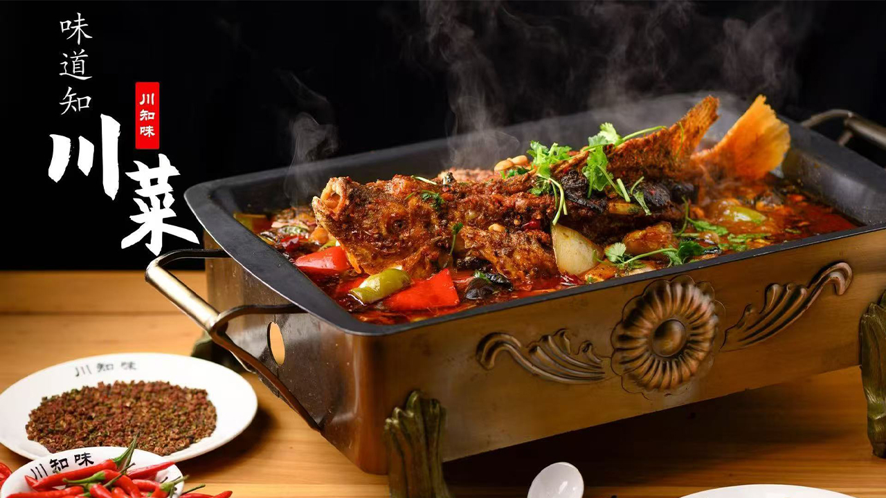 Orient-Express-Chinese-Restaurant-Roast-Fish-Baltimore Steaming Sichuan-style fish in a spicy red broth, served in an ornate metal pan with fresh cilantro and chili peppers on the side.