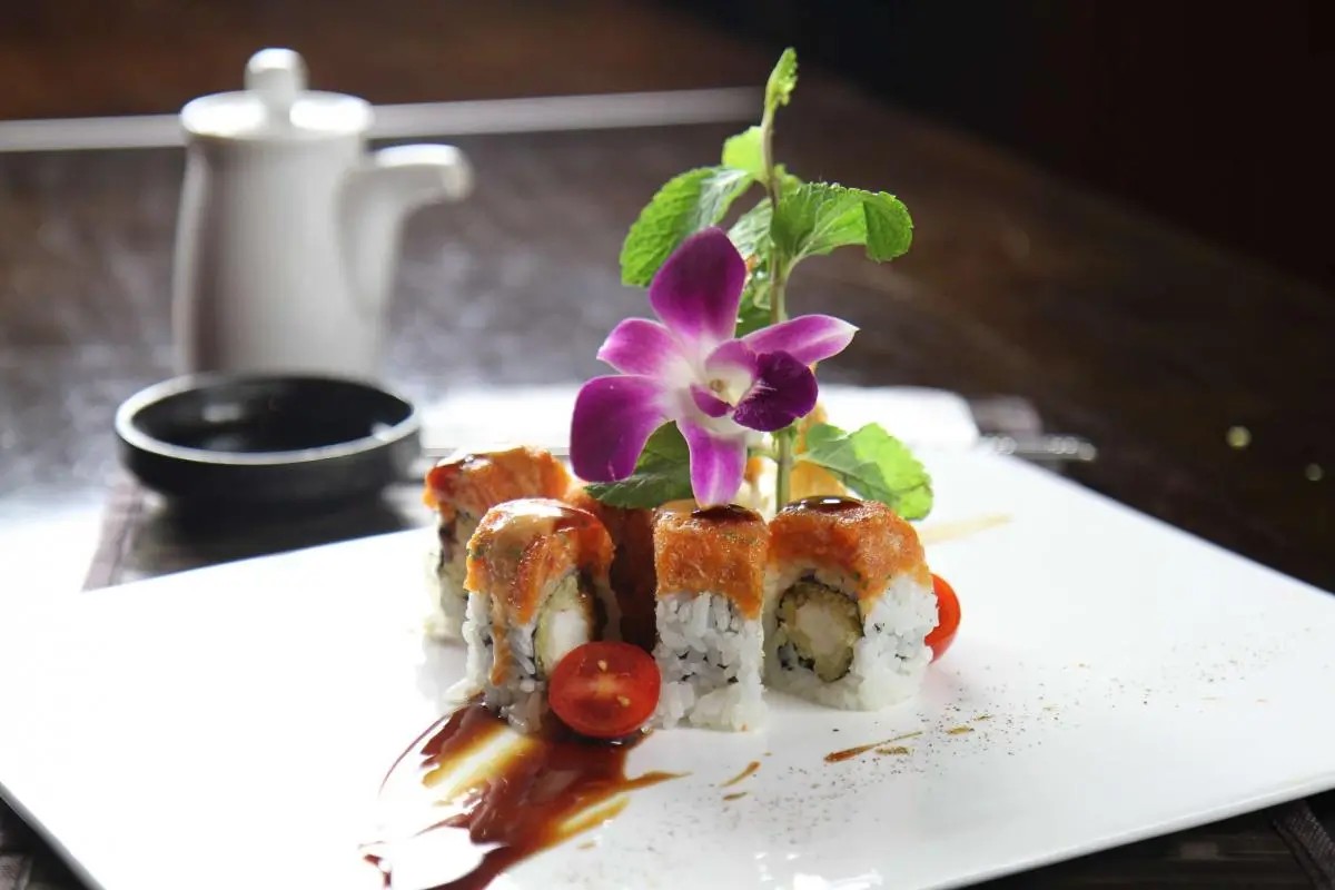 Sushi roll with spicy topping, garnished with orchid and cherry tomato, at Oriental Palace, a Asian Restaurant in Lawnside