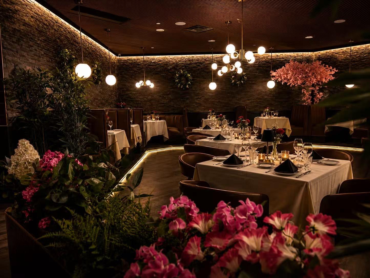 Warm dining space lined with stone walls, hanging globes and vibrant floral decor at Origami Asian Fusion Exton, an Asian Fusion Restaurant in Exton