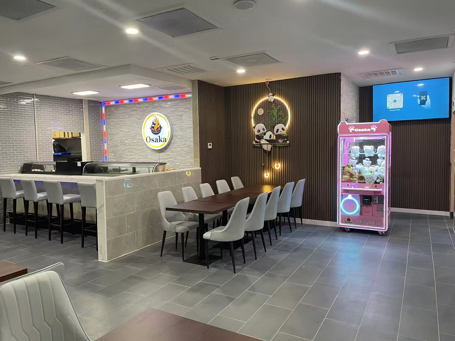 Osaka restaurant dining area with tables, claw machine, and Osaka logo