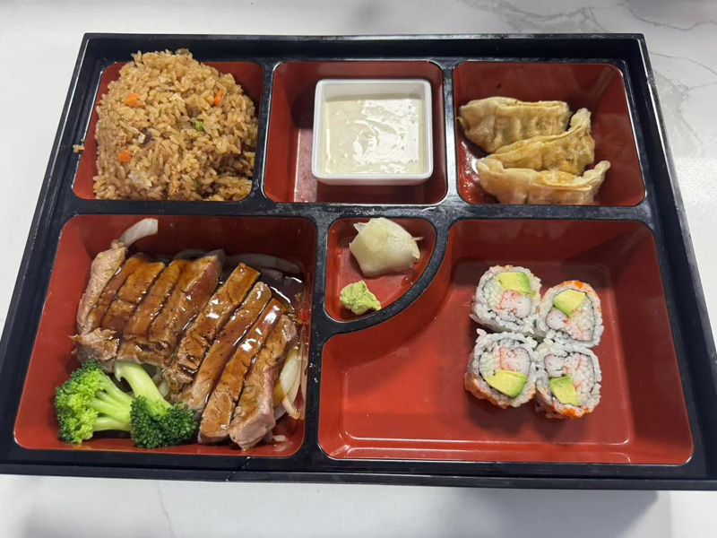 Japanese-style bento box with teriyaki steak, fried rice, gyoza, and sushi rolls at Osaka Sushi Hibachi Asian Kitchen, a Asian Restaurant in Lake City