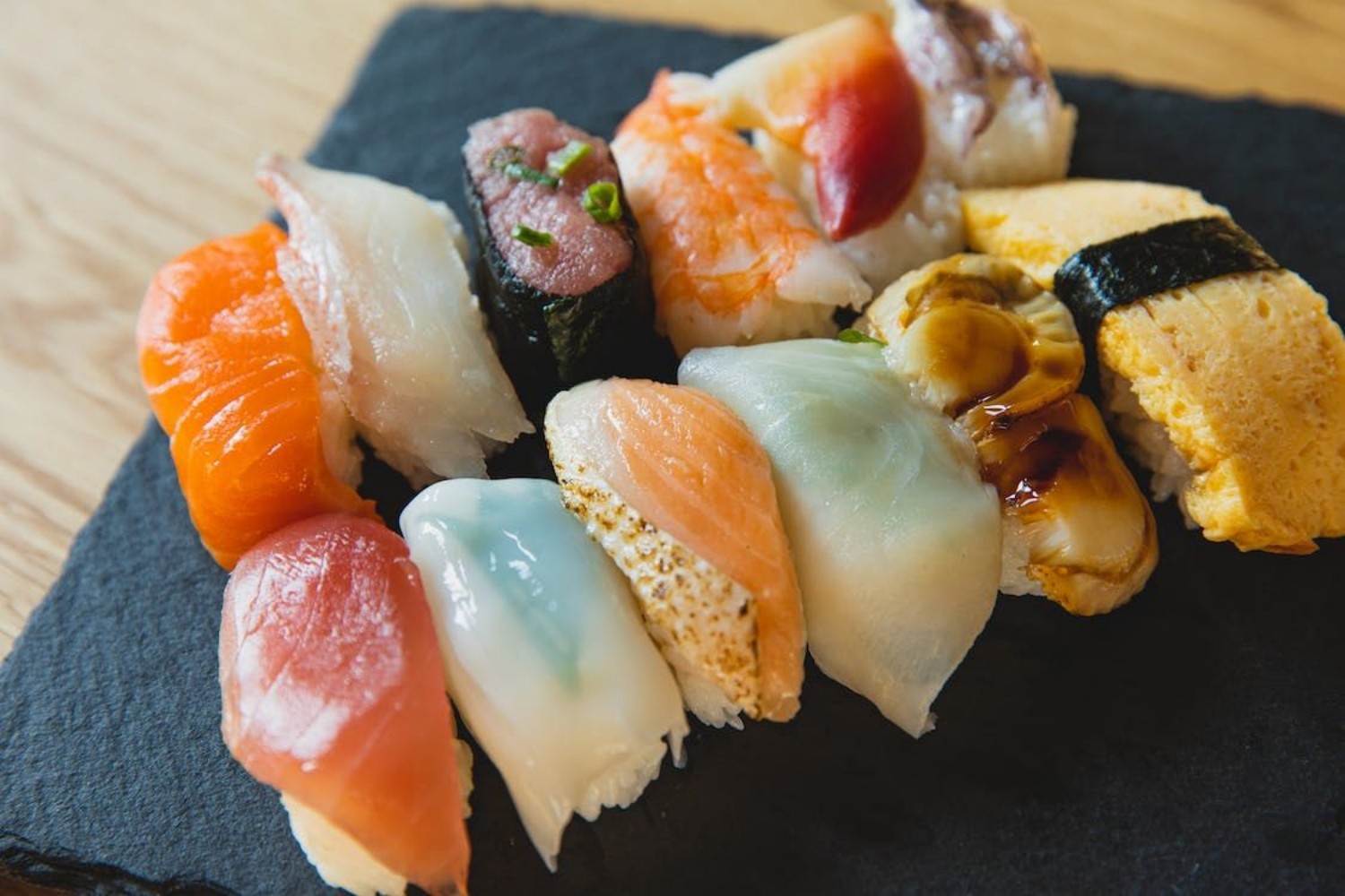 Colorful assorted nigiri sushi platter on slate plate at Osake，a Japanese Restaurant in Covington