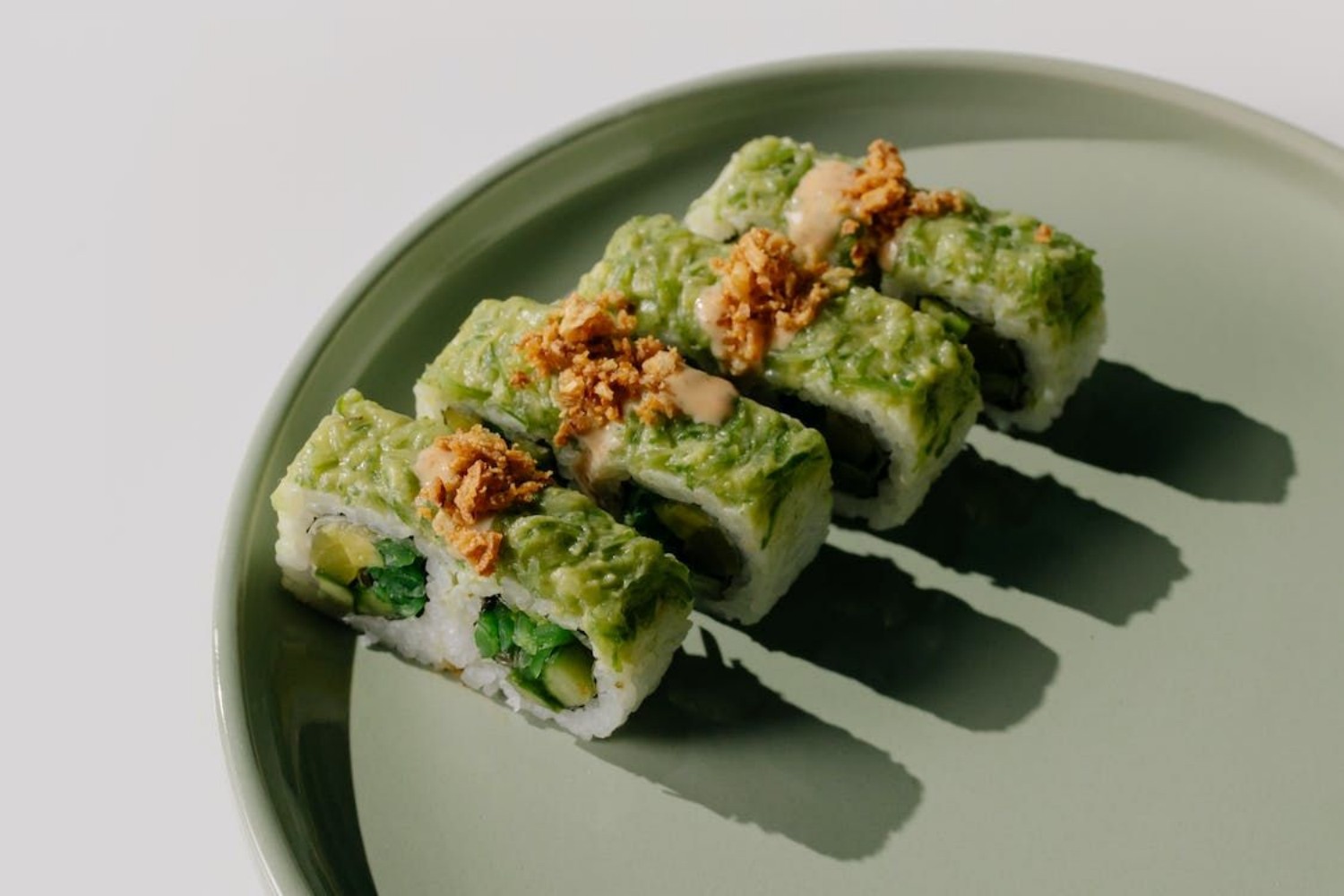 Green‑topped sushi rolls with crispy garlic toppings at Osake，a Japanese Restaurant in Covington