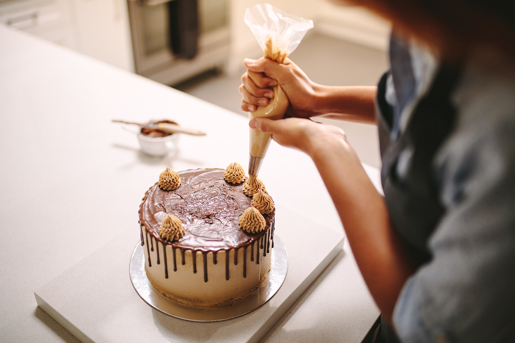 Chef decorating cake with cream at OUMI BAKERY, a Fine Dessert Bakery in Nashville