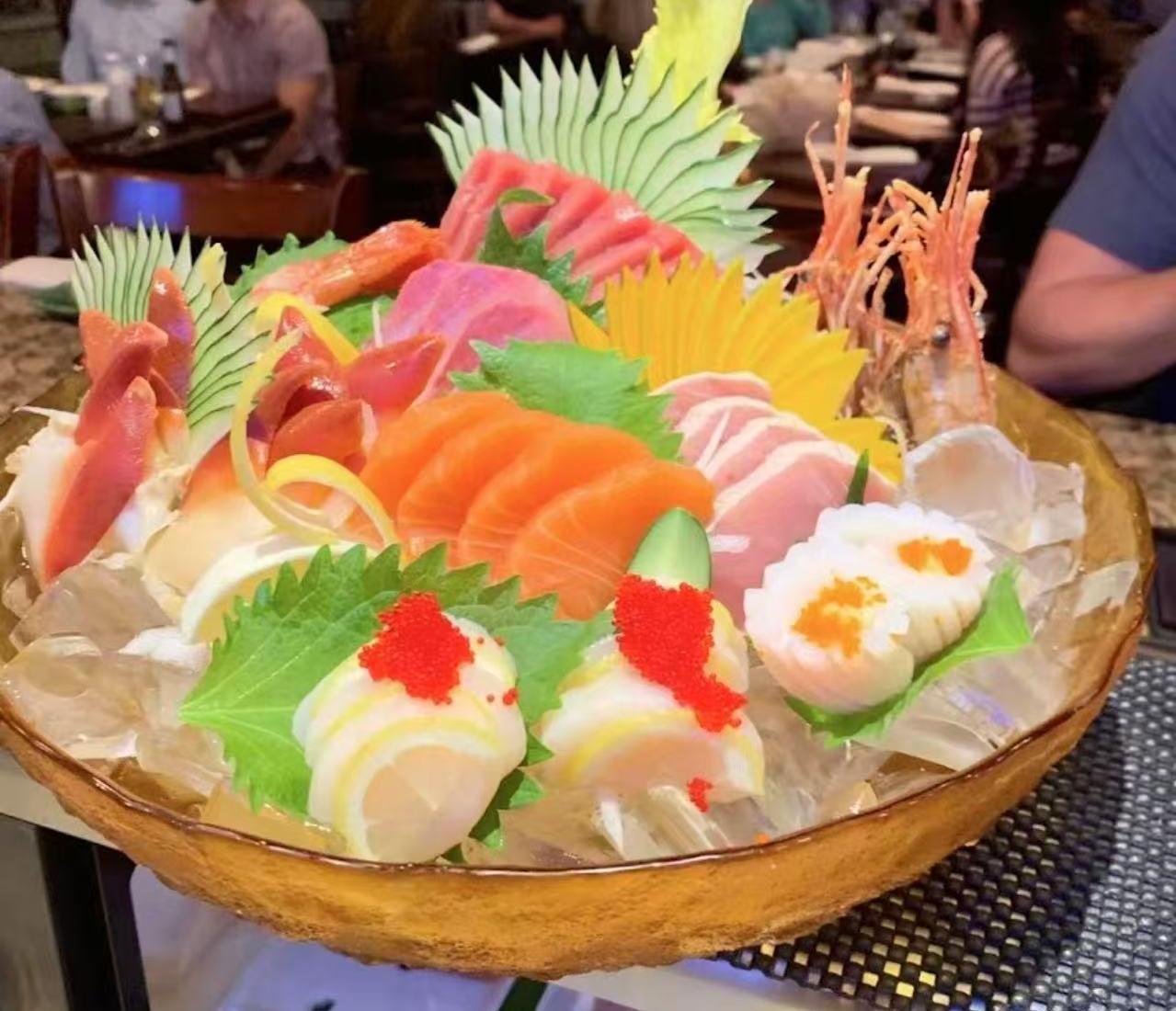 Assorted sashimi platter with fresh seafood, garnishes, and ice in a wooden bowl at Pacific Asian Bistro, a Japanese Restaurant in St. Augustine Assorted sashimi platter with fresh seafood, garnishes, and ice in a wooden bowl at Pacific Asian Bistro, a Japanese Restaurant in St. Augustine