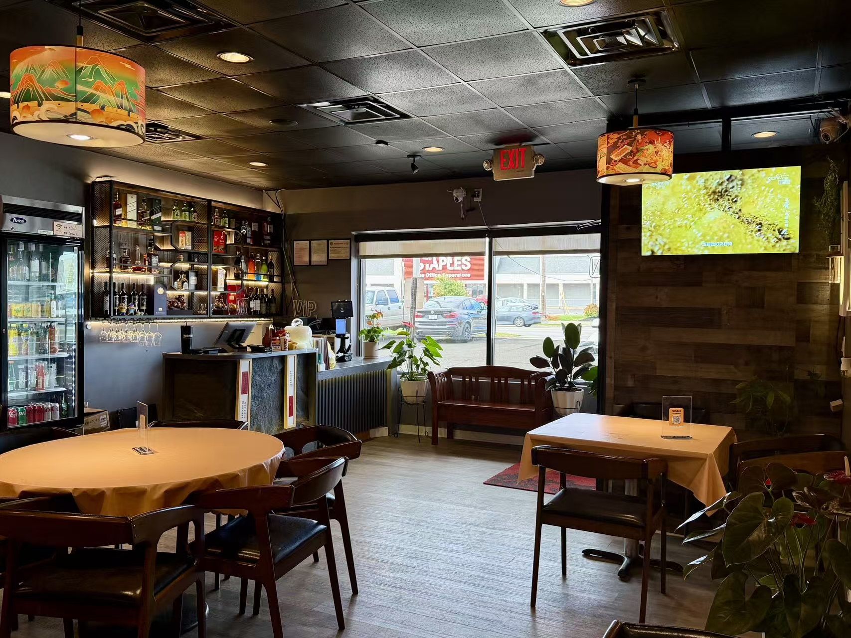 Pacific Eatery Chinese Restaurant (Kenny Rd, Columbus) has a cozy interior with warm lights, tidy tables, a stocked bar, and green plants, offering a welcoming dining vibe.