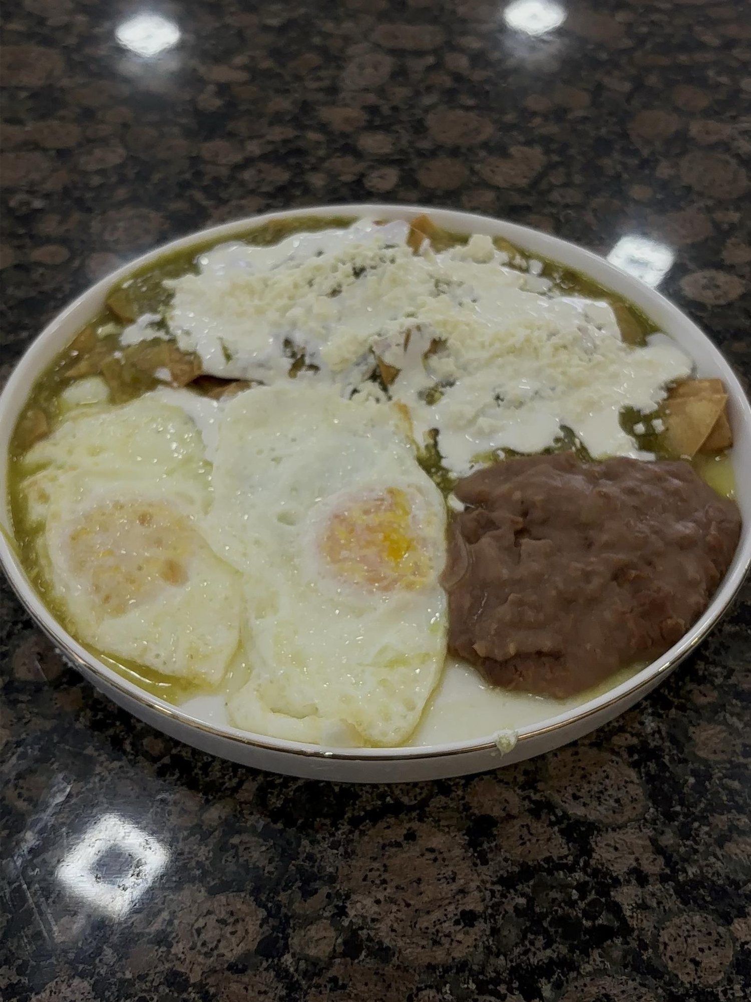 Chilaquiles Verdes with Fried Eggs and Beans at Panadería Corona, a Mexican Style Restaurant in Houston
