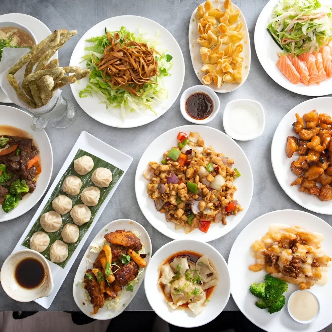 Peony-Chinese-Kitchen-Modern-American-Chinese-Restaurant-variety-of-Chinese-dishes-Laguna-Beach A variety of Chinese dishes are neatly arranged on a table, including dumplings, stir - fried dishes, salads, and fried foods, showcasing a rich assortment of Chinese cuisine at Peony Chinese Kitchen,a Modern American Chinese Restaurant in Laguna Beach