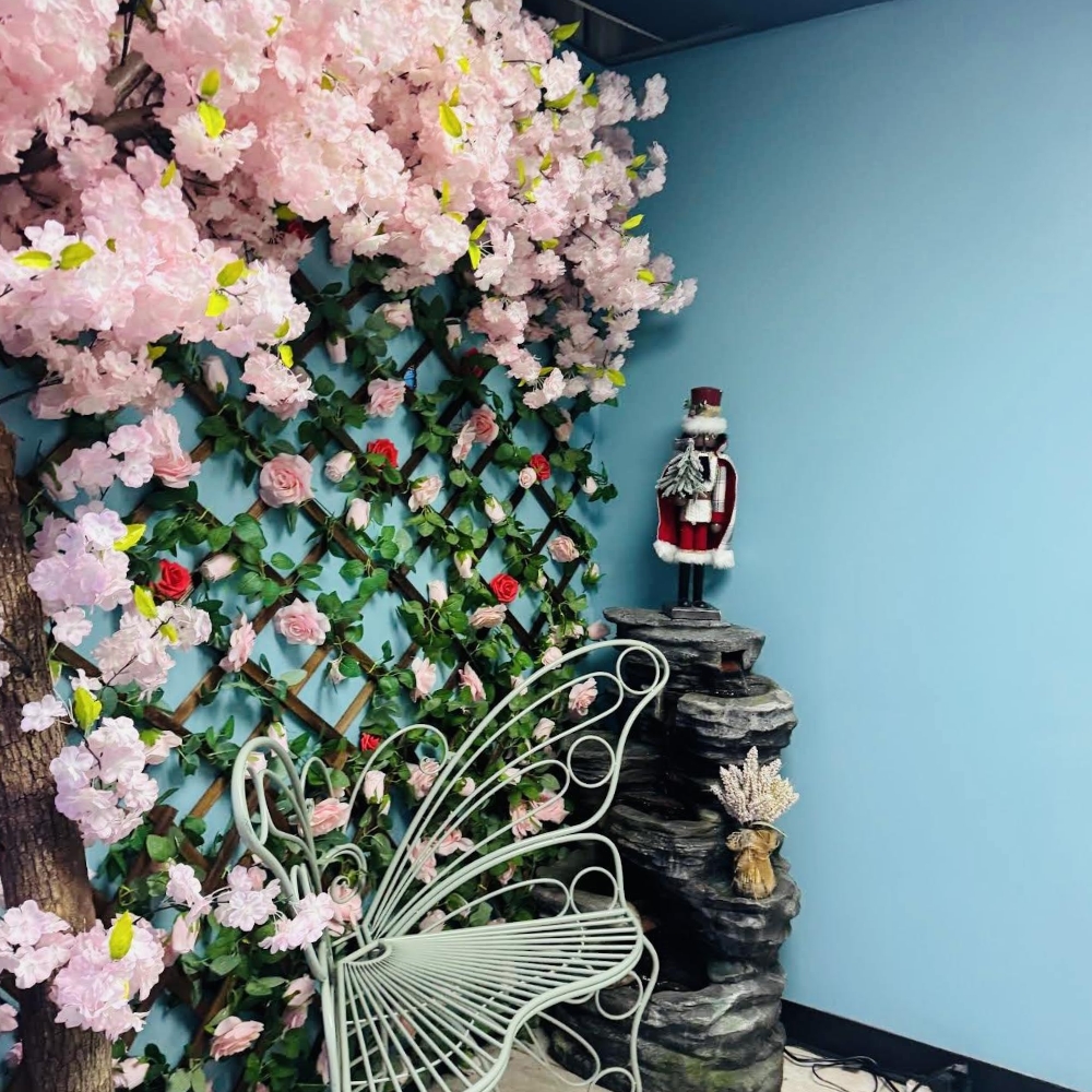 Charming corner with cherry blossom decor, butterfly chair, and fountain at Pho Lover, a Vietnamese Restaurant in Galesburg