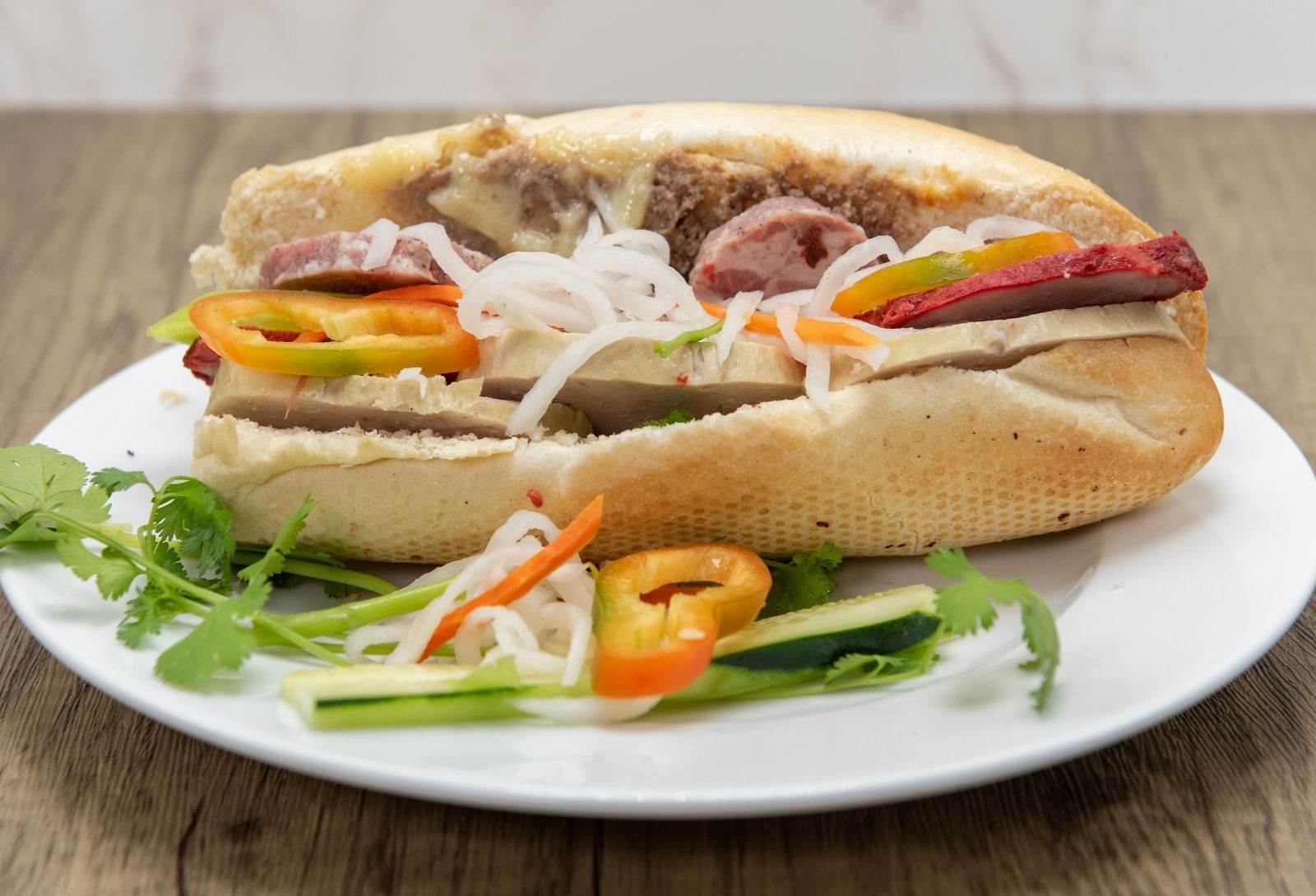 Classic assorted meat banh mi with pickled vegetables and chili peppers at Pho Saigon, a Vietnamese Restaurant in Grand Island