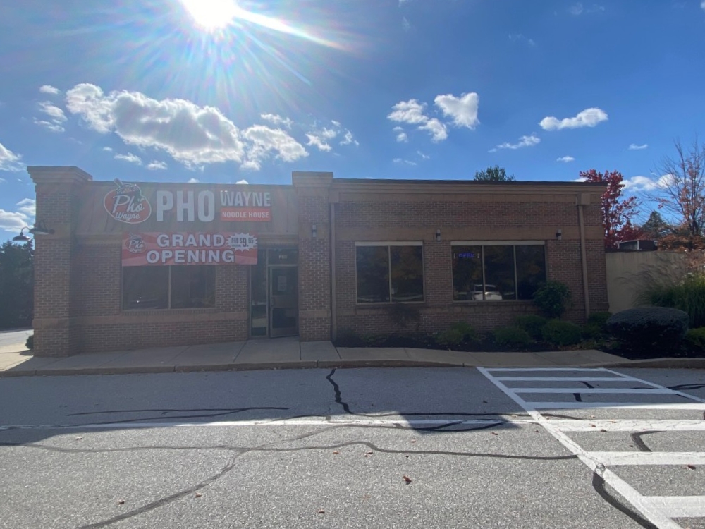 Exterior of Pho Wayne with brick building, grand opening banner, sunny sky at Pho Wayne, a Vietnamese Restaurant in Berwyn