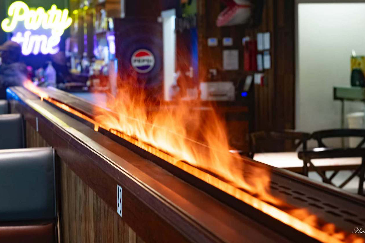There are blazing flames in the picture, creating a warm cooking atmosphere of Seafood Restaurant Pier 18 Cajun Seafood & Grill with traditional decor in Texas