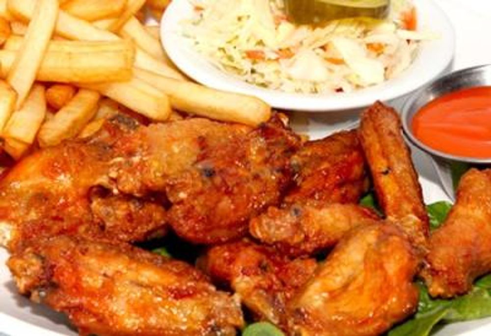 Spicy fried chicken wings served with fries, coleslaw and hot sauce at Pizzeria 67, a Pizza Restaurant in Grand-Mère