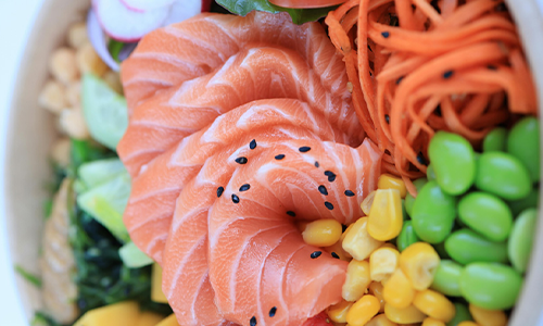 Colorful salmon poke bowl with corn, edamame, and veggies at Poke House Huntington, a Hawaiian restaurant in Huntington