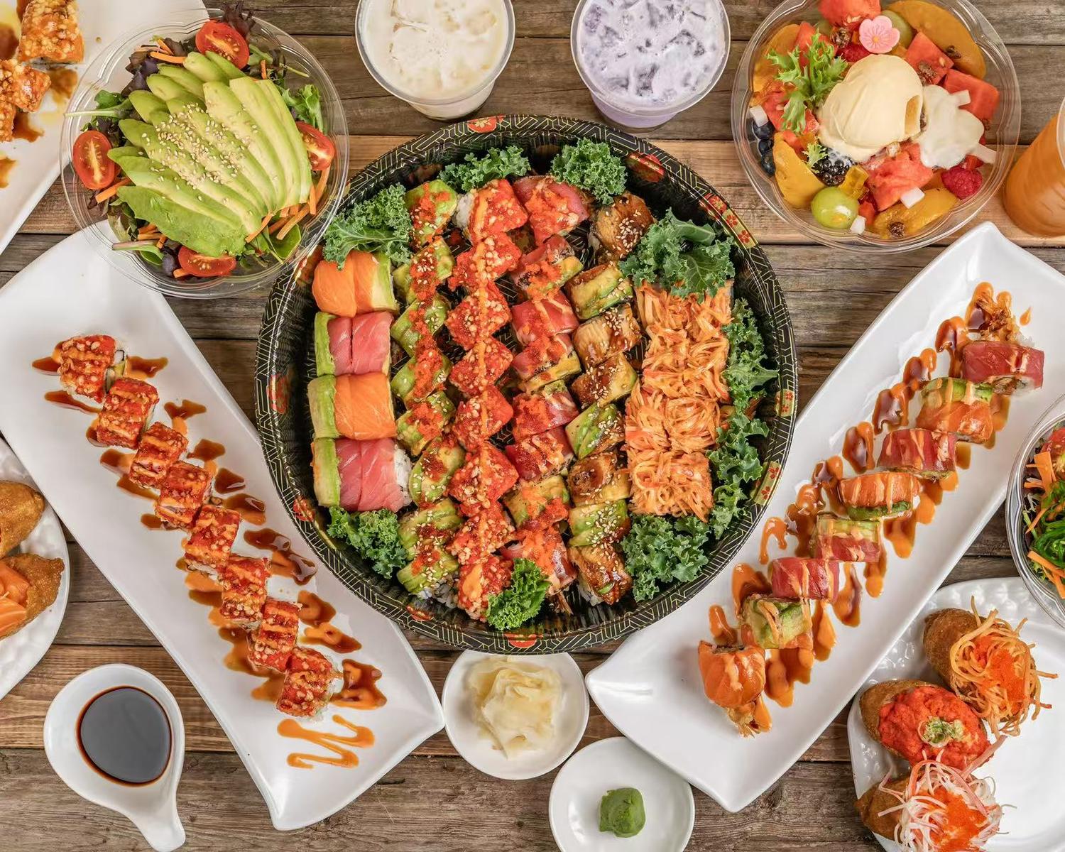 Assorted sushi platter with rolls, sashimi, salads, and drinks at Poke House Huntington, a Hawaiian restaurant in Huntington