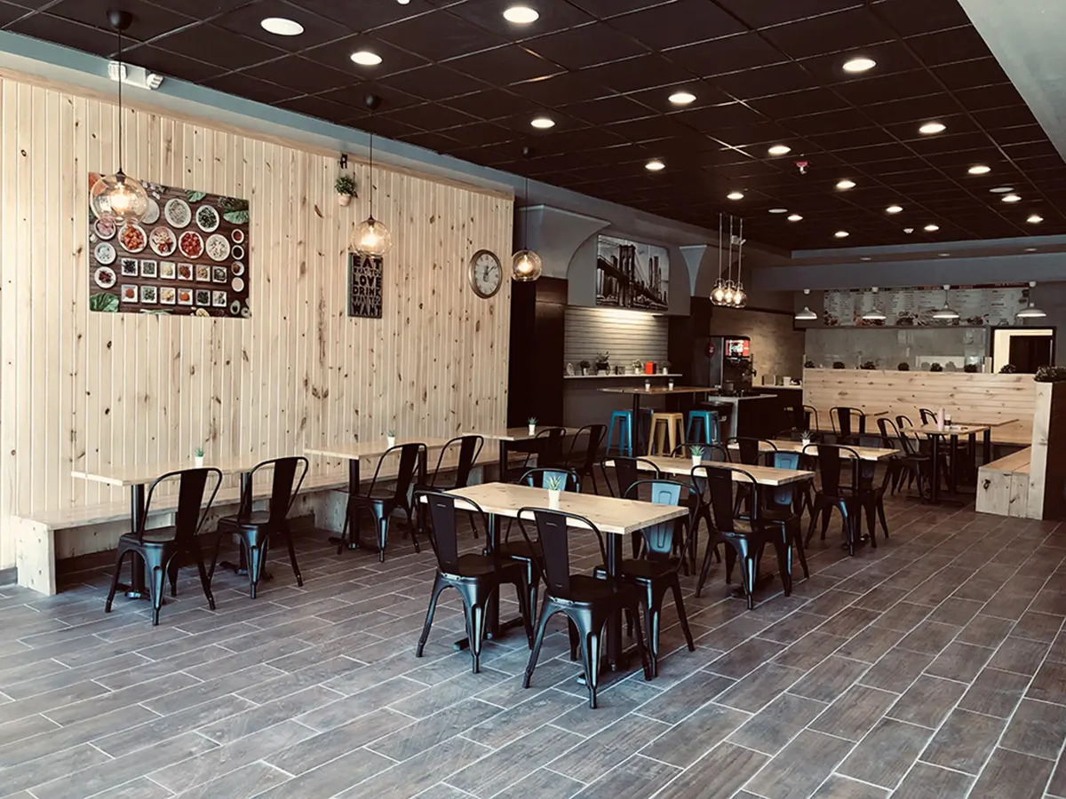 Pokéloha-Asian-Fusion-Restaurant-Dining-Area-1-KS Spacious dining area featuring brick wall and colorful stools at Pokéloha, a Asian Fusion Restaurant in Woonsocket