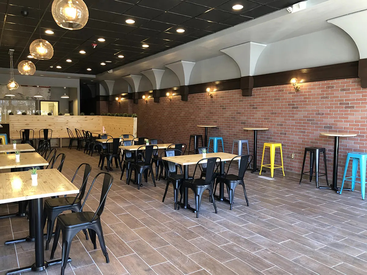 Pokéloha-Asian-Fusion-Restaurant-Dining-Area-2-KS Well - lit dining area with wooden - wall and black ceiling at Pokéloha, a Asian Fusion Restaurant in Woonsocket