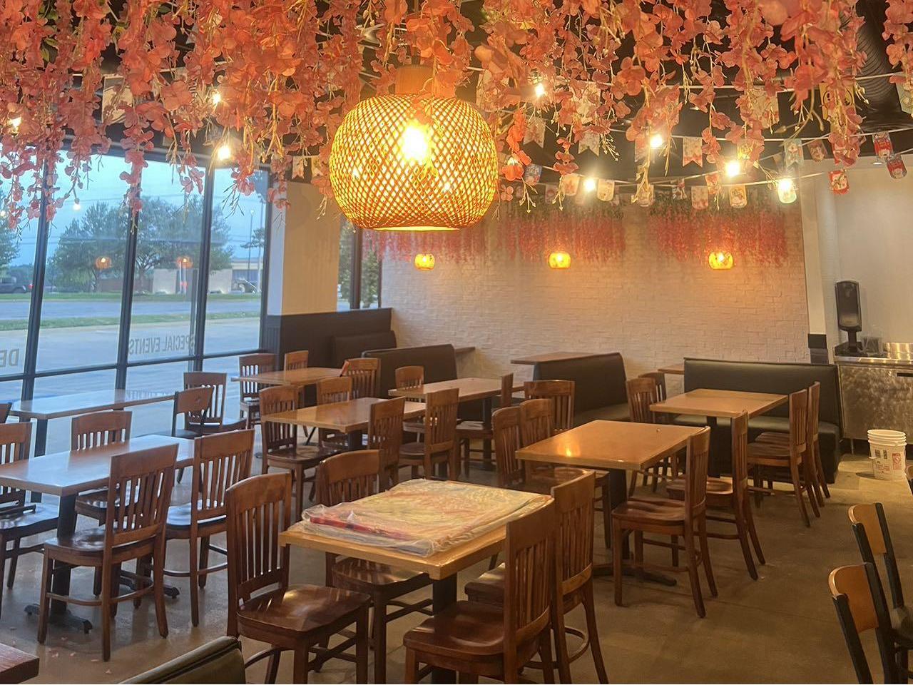 Dining area with floral decor and rattan lamp at Pokéloha, a Asian Fusion Restaurant in Woonsocket