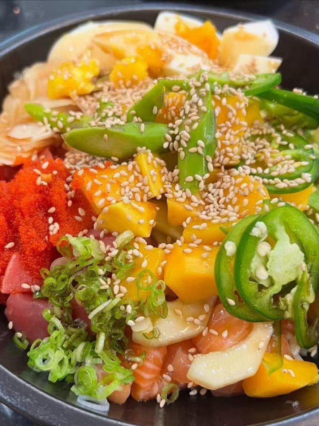 Colorful seafood poke bowl with mango, fish roe, and sesame at Poke Zone, a Japanese Restaurant in Edgewater