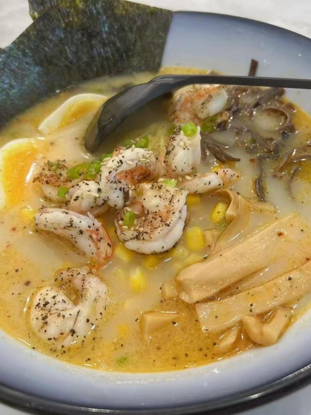 Creamy shrimp ramen with corn, menma, and seasoned shrimp at Poke Zone, a Japanese Restaurant in Edgewater