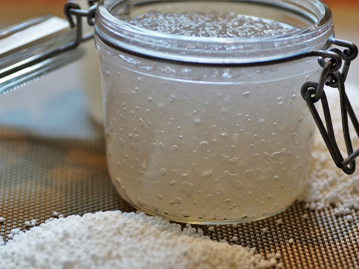 Glass jar of clear tapioca pearls on a mesh surface with scattered pearls at Pop Onigiri, a Dessert Shop in Bonita Springs