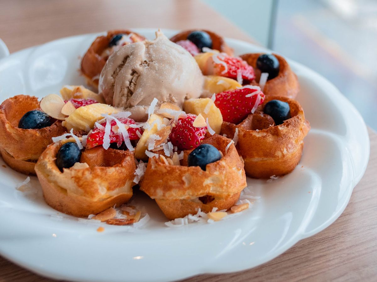 Waffle bowl platter with fresh fruit, ice cream, and coconut toppings at Pop Onigiri, a Dessert Shop in Bonita Springs