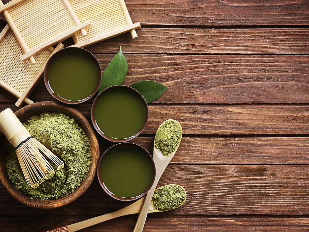 Matcha tea set with bowls, powder, whisk, and bamboo tools on wood at Pop Onigiri, a Dessert Shop in Bonita Springs