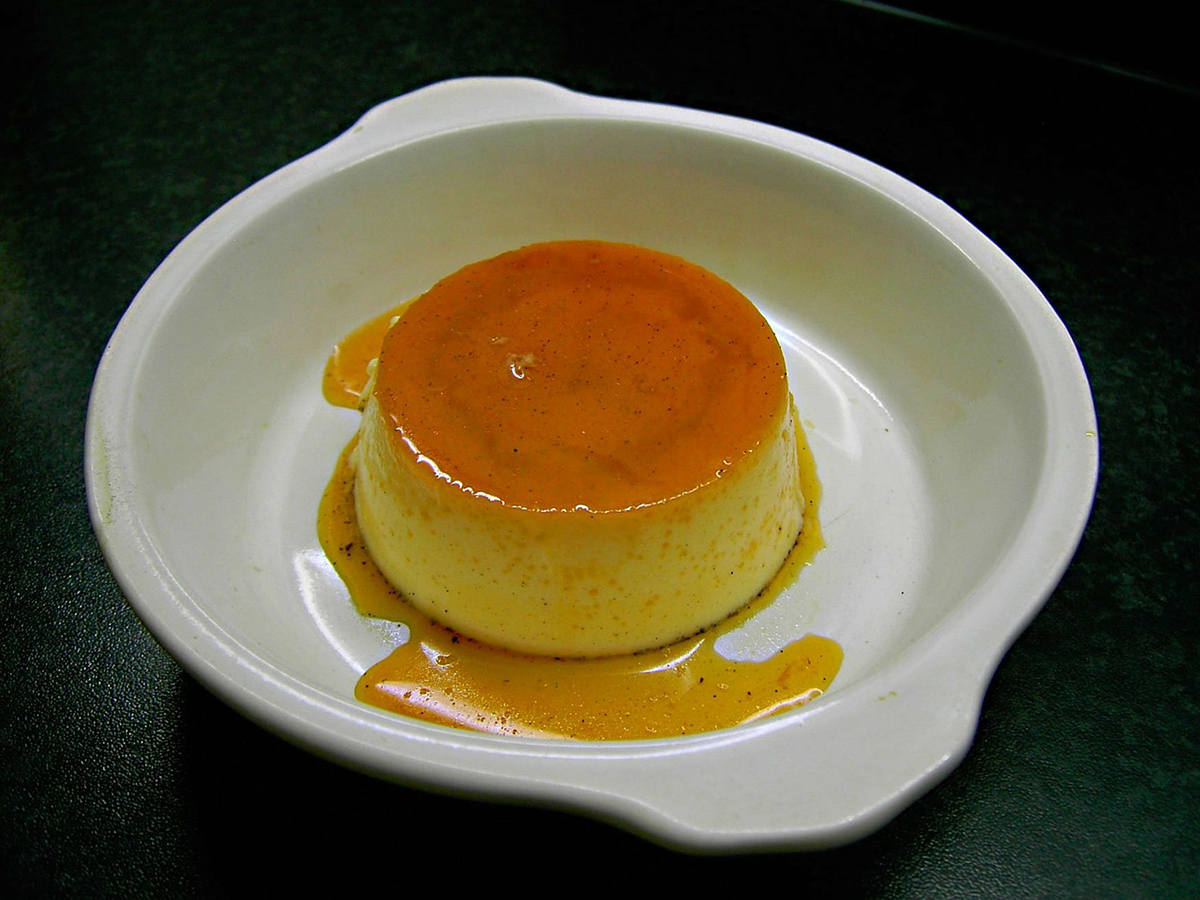 Caramel flan dessert in a white dish with glossy caramel sauce at Pop Onigiri, a Dessert Shop in Bonita Springs