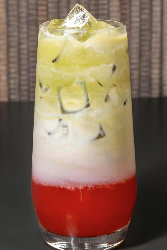 Layered red, white, and green iced beverage with ice cubes at Pop Ice Cream, a Dessert Shop restaurant in Bonita Springs