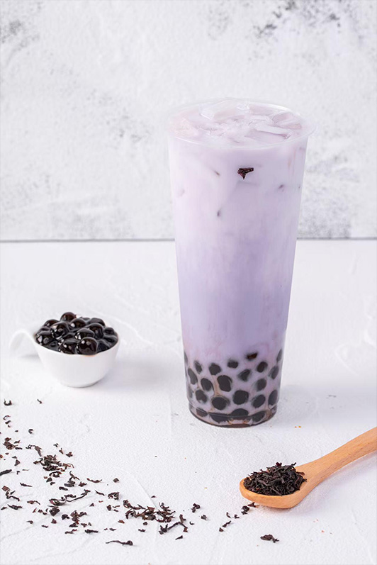 Purple taro milk tea with tapioca pearls, presented with loose tea leaves at Pop Ice Cream, a Dessert Shop restaurant in Bonita Springs