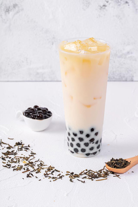 Light-colored milk tea with tapioca pearls and green tea leaves garnish at Pop Ice Cream, a Dessert Shop restaurant in Bonita Springs