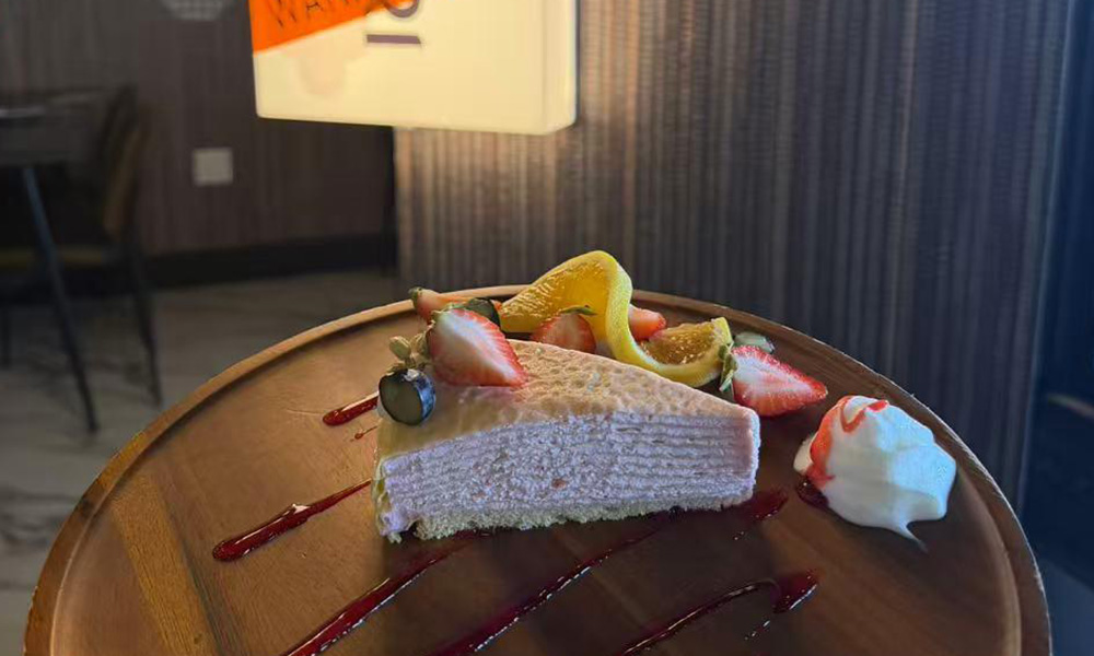 Pink mille crepe cake slice with fresh berries and berry sauce drizzle at Pop Ice Cream, a Dessert Shop restaurant in Bonita Springs