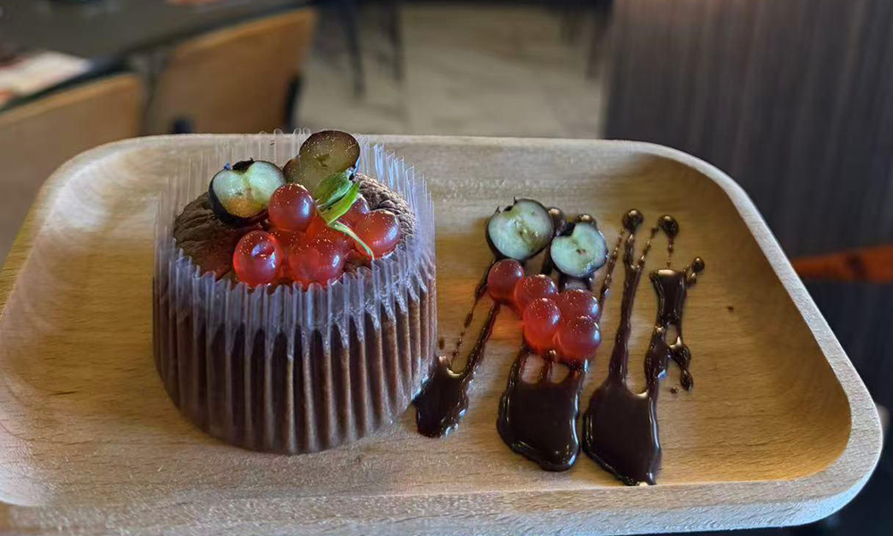 Chocolate cupcake topped with red currants, grapes and chocolate sauce drizzle at Seafood&wings, a Seafood Restaurant in Greenville at Pop Ice Cream, a Dessert Shop restaurant in Bonita Springs