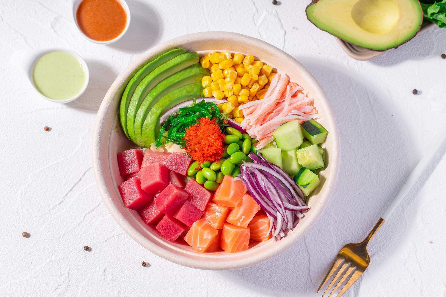 Tuna and salmon poke bowl with avocado, corn, crab, cucumber, edamame and sauces at Pop Ice Cream, a Dessert Shop restaurant in Bonita Springs