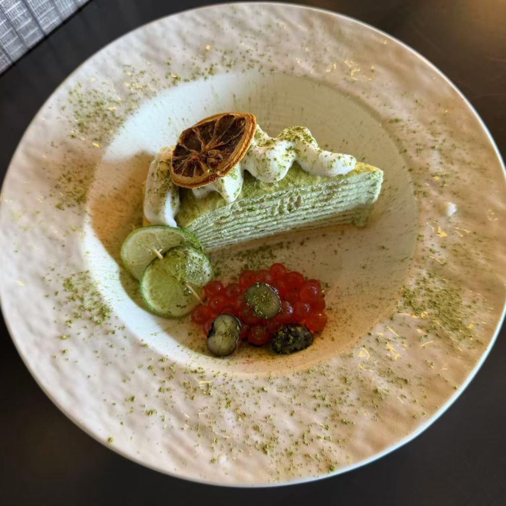 Strawberry mille crepe cake with orange slices and berry garnish at Pop Onigiri, a Japanese Restaurant in Bonita Springs