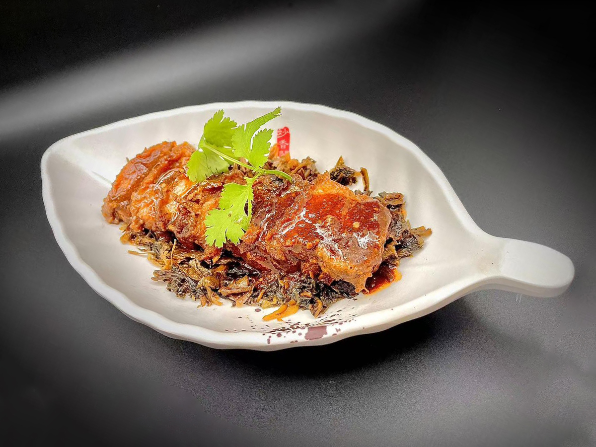 Stewed pork belly with preserved vegetables garnished with fresh cilantro at Precious, a Chinese Restaurant in Austin