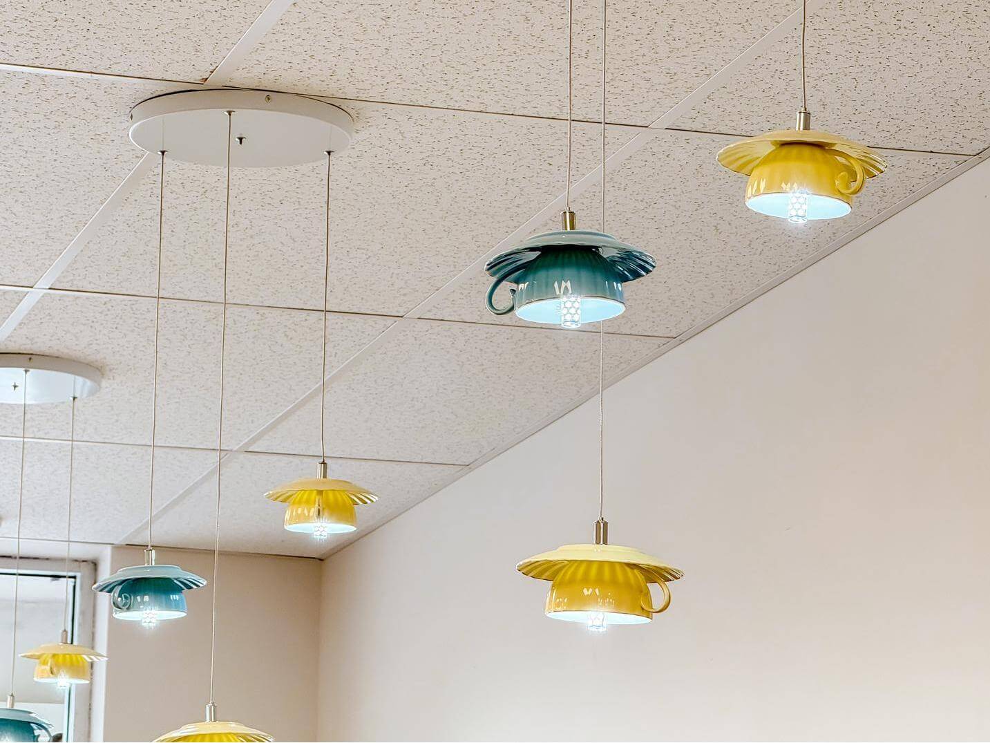 Cup - shaped pendant lights hanging from the ceiling at Bliss Café, a Coffee Shop in Oviedo