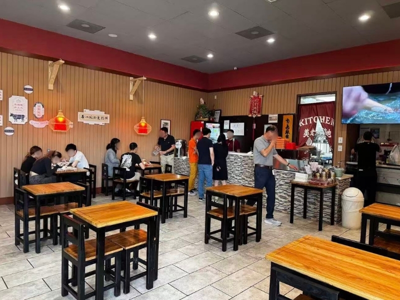 Busy dining area with customers at Qilu Beef Soup, a Chinese Restaurant in Houston.