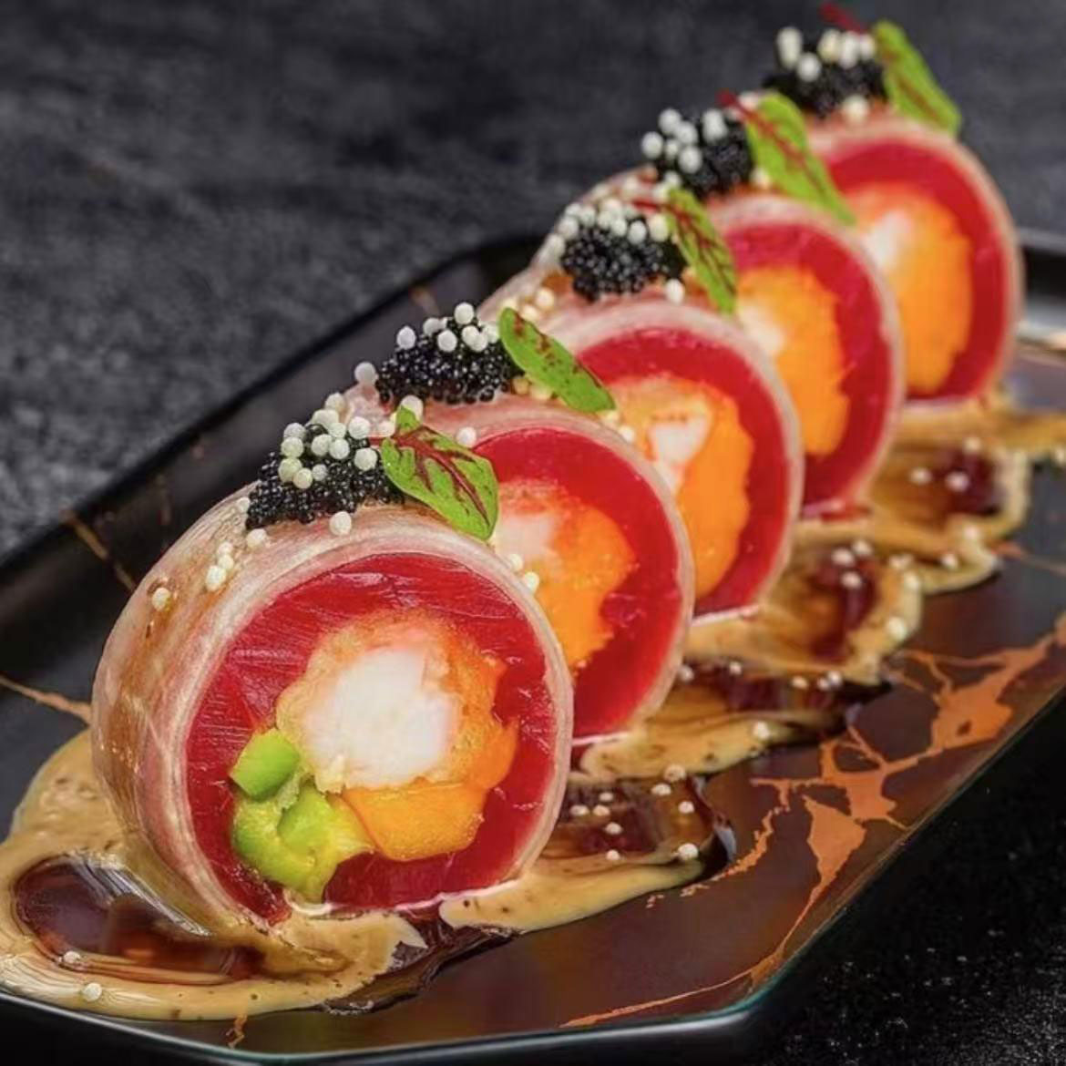Sliced tuna sashimi roll topped with caviar, microgreens and creamy sauce on black marbled plate at Quan Izumi , an Japanese Restaurant in Centereach