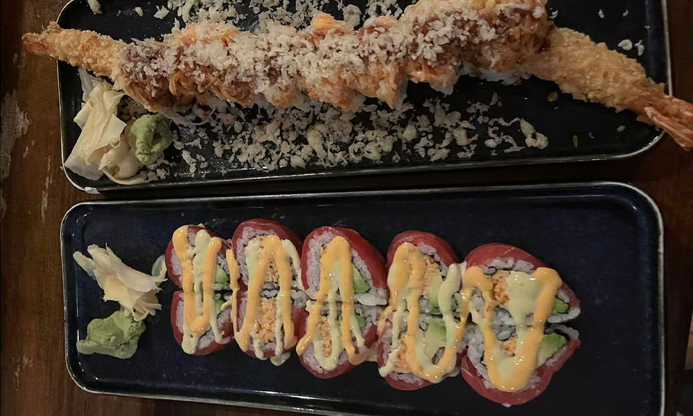 Two sushi trays: tempura shrimp crunch roll and tuna wrap roll with creamy sauce alongside ginger and wasabi at Quan Izumi , an Japanese Restaurant in Centereach