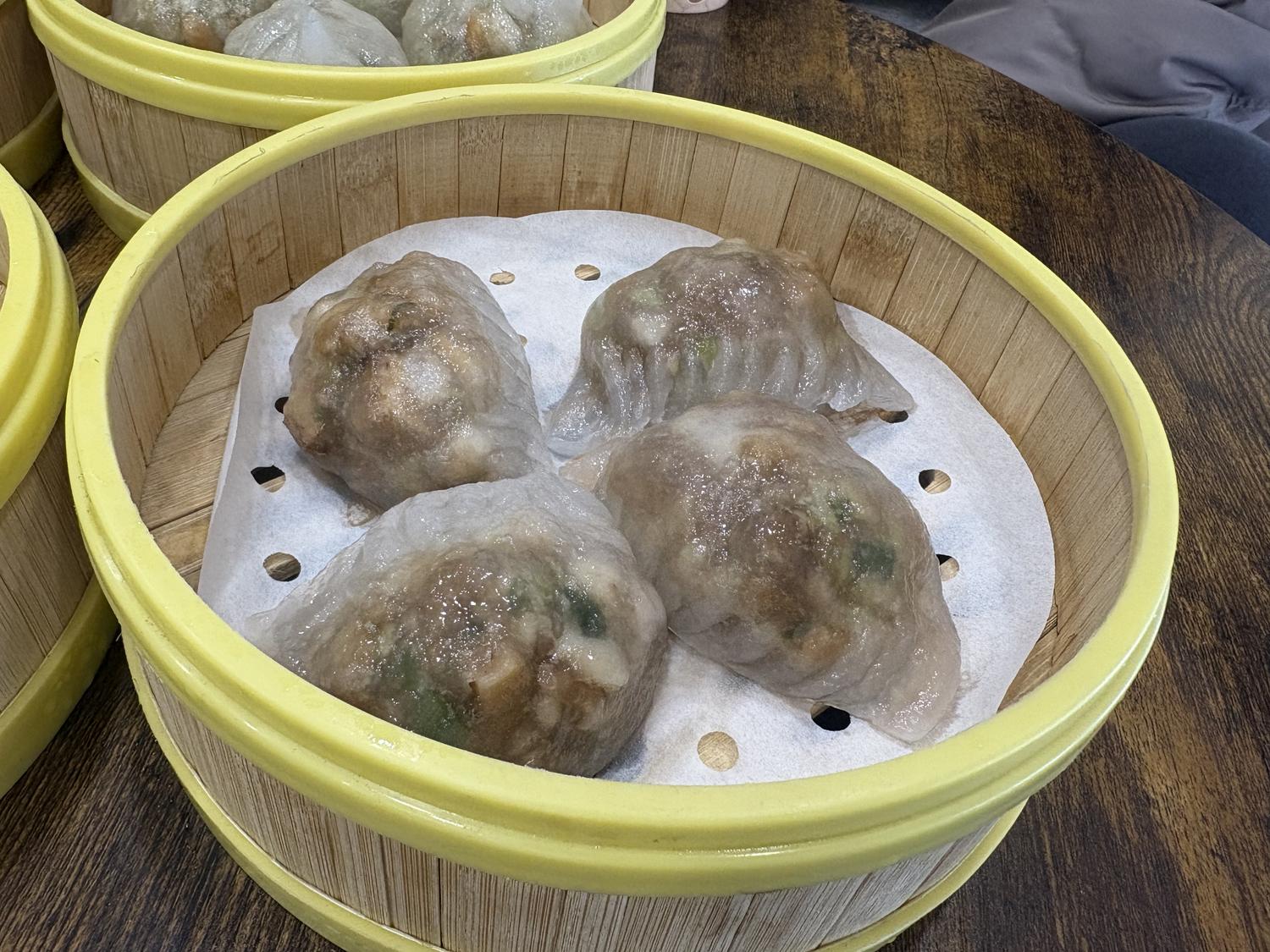Four crystal rice dumplings in a bamboo steamer at Rainbow 1 Bakery, a Bakery in Brooklyn