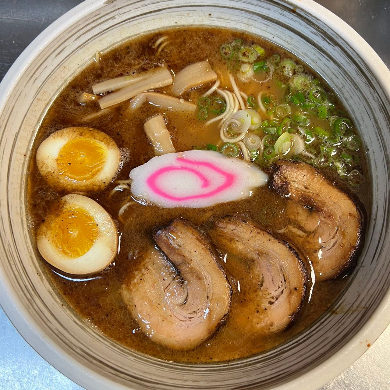 Rich shoyu ramen with chashu pork, soft boiled eggs, bamboo shoots and narutomaki