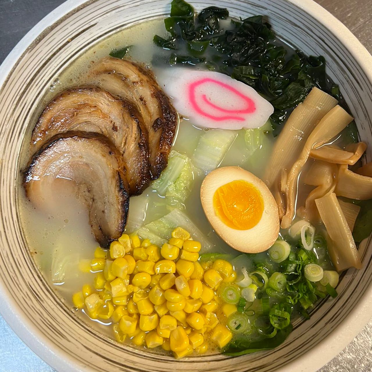 Creamy tonkotsu ramen with chashu pork, corn, seaweed, egg and bamboo shoots