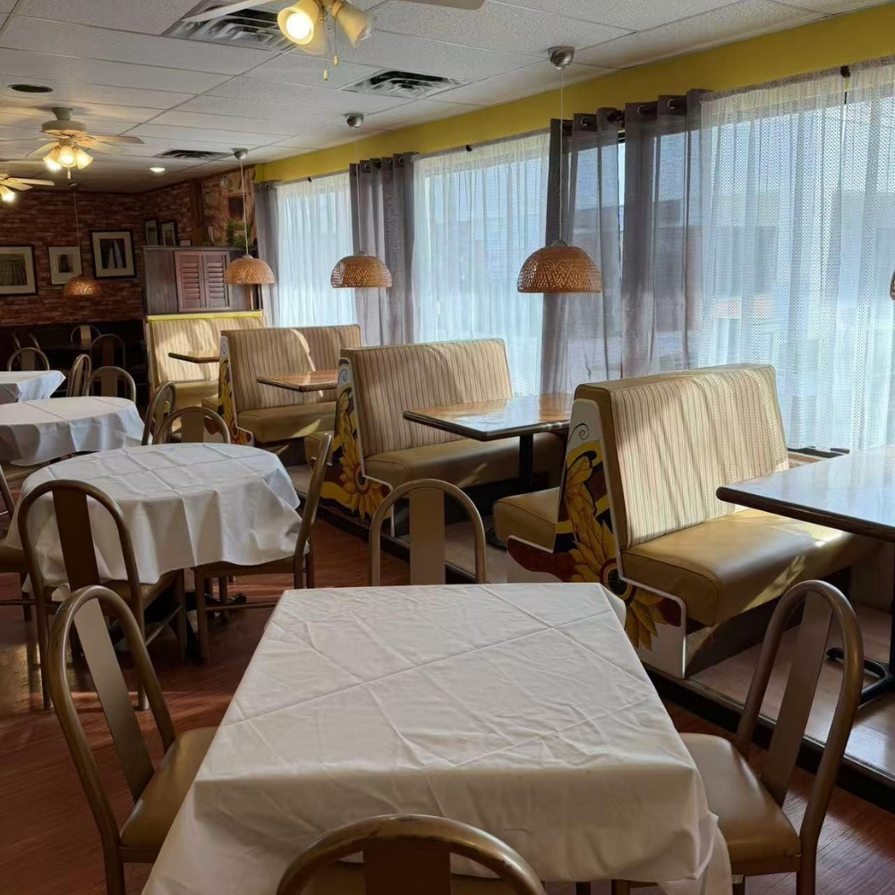 Dining room with tables and sunflower booths at Raku Sushi, a Japanese Restaurant in Easton