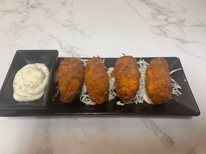 Fried Oysters - Deep - fried oysters served with a creamy dipping sauce and shredded cabbage at Ramen Jin, a Ramen restaurant in Houston