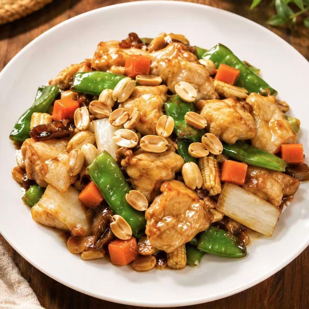 Chicken and vegetable stir-fry with peanuts, snow peas, and carrots in a brown sauce