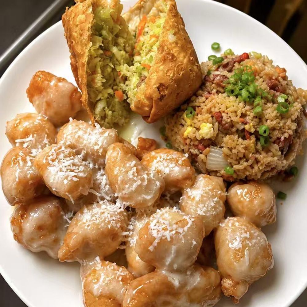 Creamy coconut shrimp balls, a fried spring roll, and fried rice on a white plate