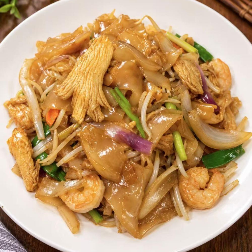 Stir-fried flat rice noodles with shrimp, chicken, onion, and bean sprouts Stir-fried flat rice noodles with shrimp, chicken, onion, and bean sprouts