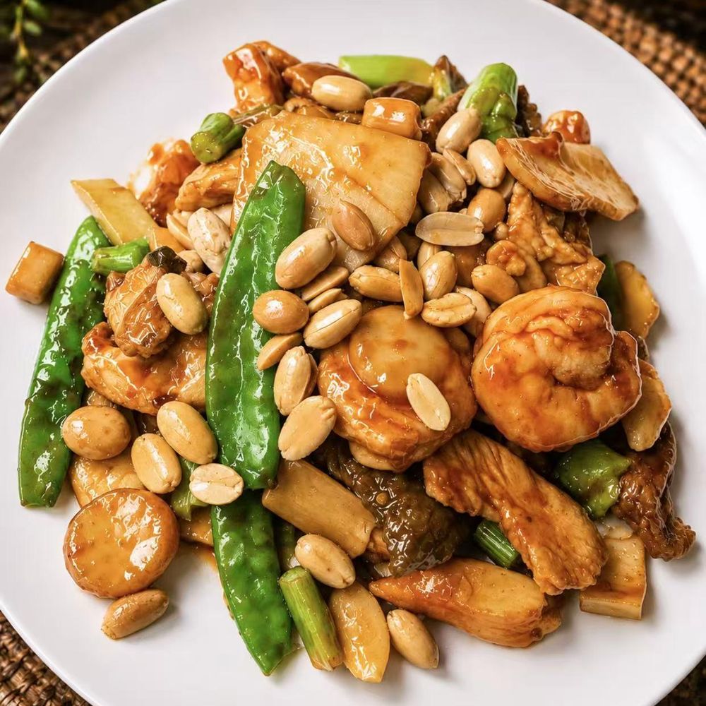 Stir-fried shrimp, chicken, snow peas, and peanuts in a glossy brown sauce Stir-fried shrimp, chicken, snow peas, and peanuts in a glossy brown sauce