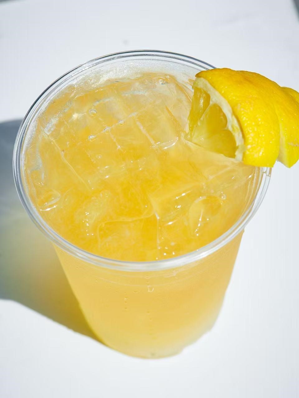 Refreshing lemon iced tea with a lemon wedge at Rise & Grind Cafe, a Coffee Shop in Los Angeles